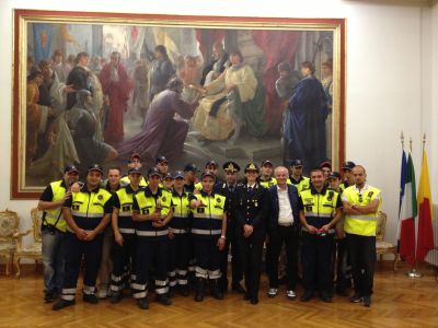 Foto di gruppo con il Tenente Miche Lamberti sotto il quadro che raffigura la consegna della Pergamena Bianca da parte del Re Ferdinando I d'Aragona nel 1460.